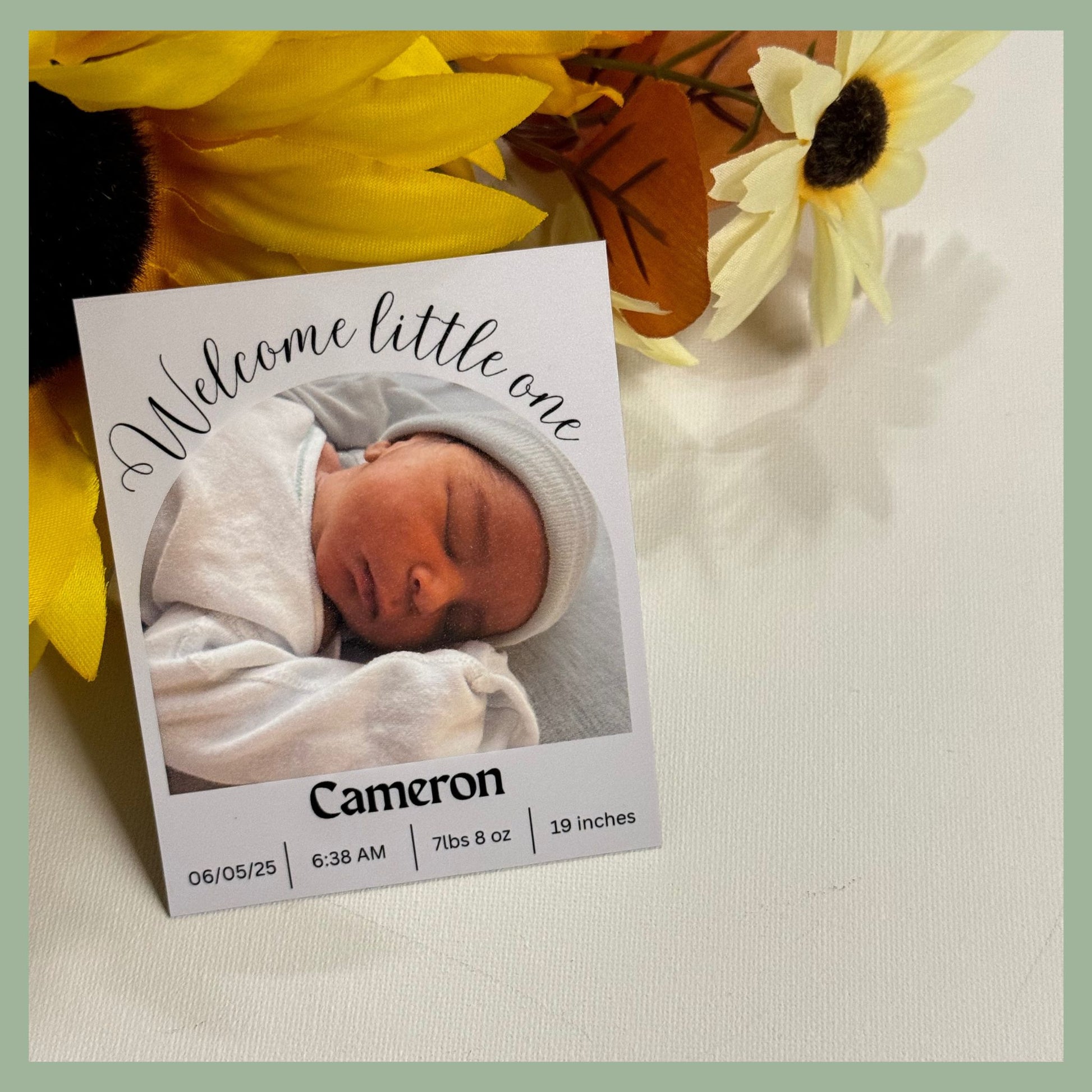 Newborn baby photo with 'Welcome little one' text and baby's name and birth details